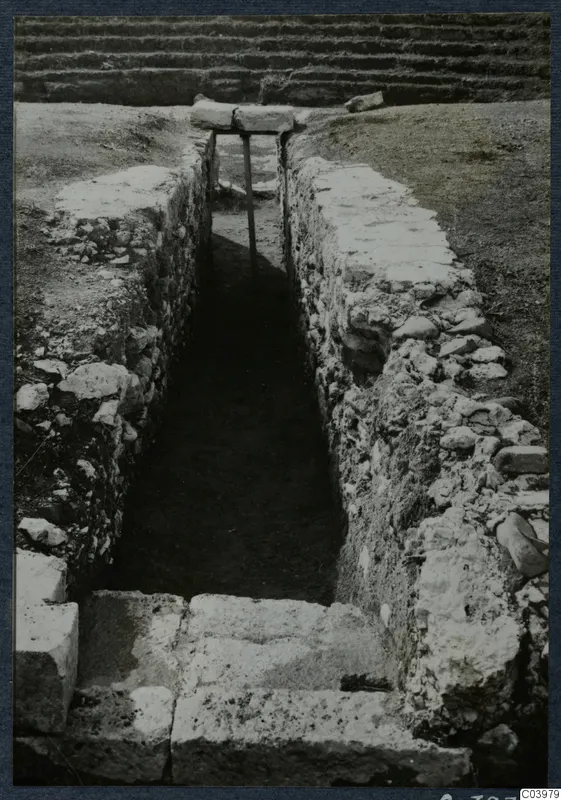 Narrow excavated cutting with stone-faced walls and steps at the theatre at Soli