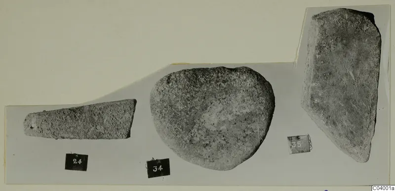 Three stone objects from Lapithos, labelled 24, 34 and 35, photographed side by side on a grey card mount