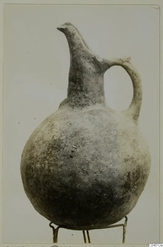 Round-bodied jug with a tall trefoil-type neck and one loop handle, standing on a wire stand.