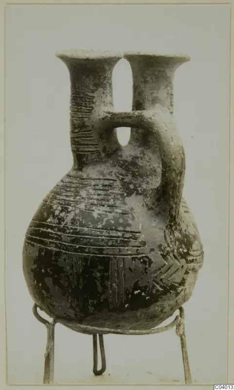 Pottery Red Polished II Jug from the Vrysi tou Barba tombs at Lapithos, with two necks and a strap handle