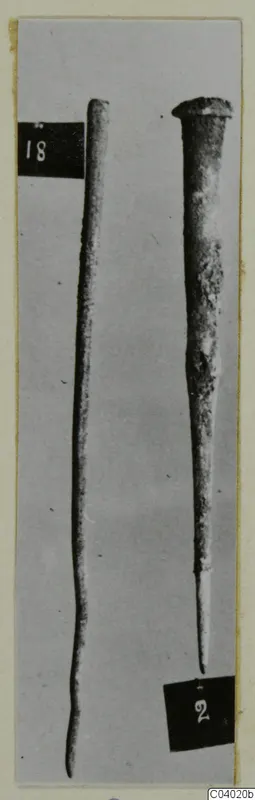 Two bronze tools photographed upright, one long and thin, the other with a flared head and a pointed end