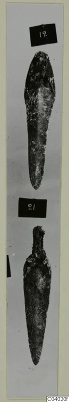 Two corroded bronze tools from Amathus, each shown in its own photograph with a number label