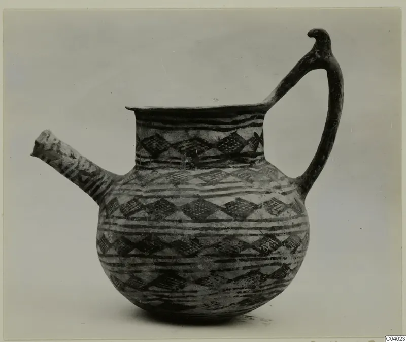 Jug with a long spout and a handle ending in a bird-like head, decorated with dark bands and lozenges