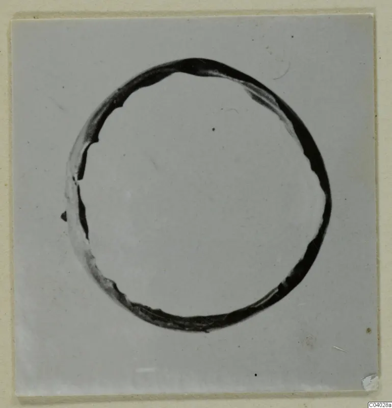 Dark ring-shaped object centred on a pale plain ground, a find from the Kastros tombs at Lapithos.