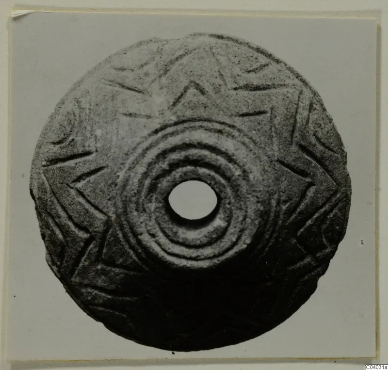Round stone disc with a central hole, concentric rings and an incised star-like pattern, from Idalion