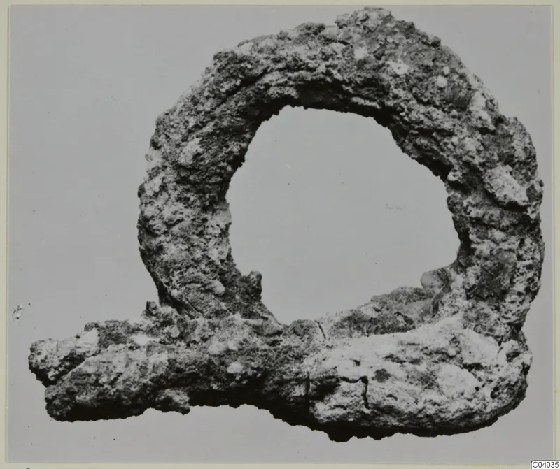 Corroded metal loop fragment with a projecting bar, from Idalion