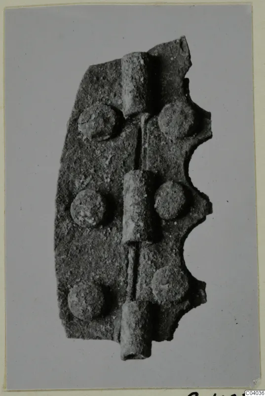 Corroded metal hinge-like fitting with three knuckles and six rivet heads, Idalion bronze and metalwork