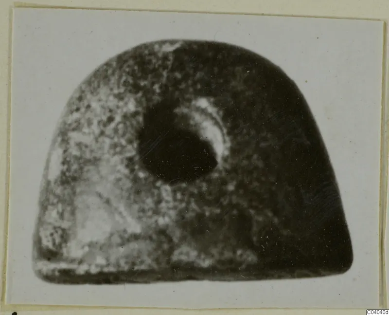 Dome-shaped stone object with a large central hole, photographed on a card mount, from Idalion