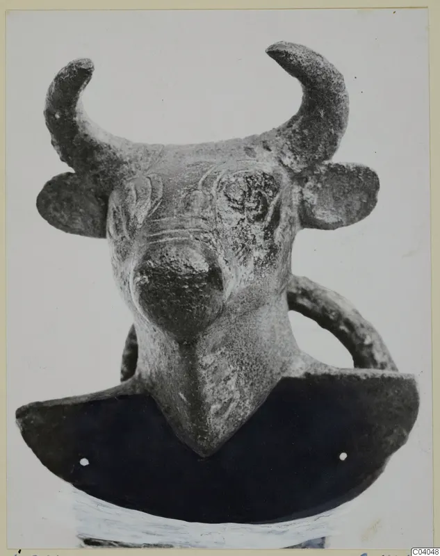 Bull's head with curved horns and a ring handle, from Idalion, on a dark curved base