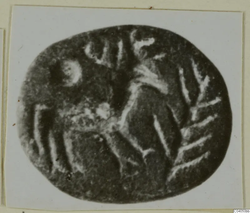 Engraved oval seal stone with pale incised lines, photographed on a white card