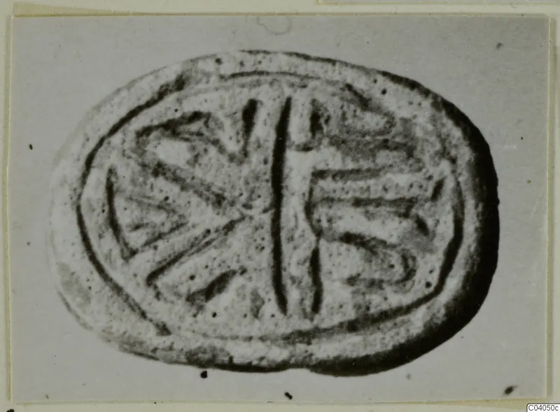 Oval stone seal with an incised design of a central vertical line and radiating lines on each side