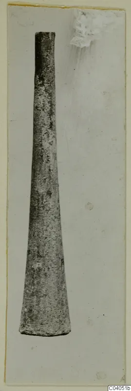 Iron object, long and tapering, shown upright on a pale mounted photograph card