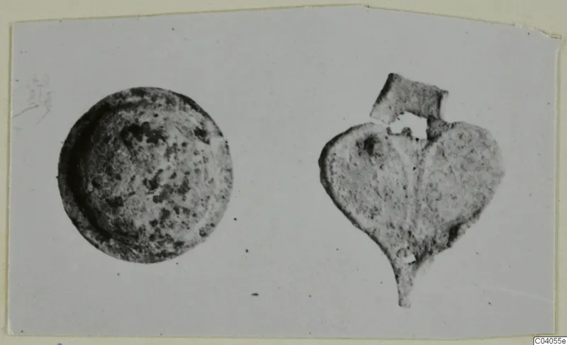 Bronze mountings from Idalion: a round disc and a heart-shaped fragment with a tab, shown side by side