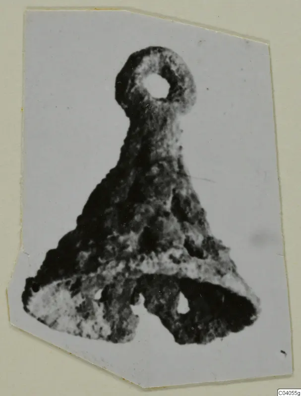 Bronze horse-trapping with a loop at the top and a triangular lower part with two holes.