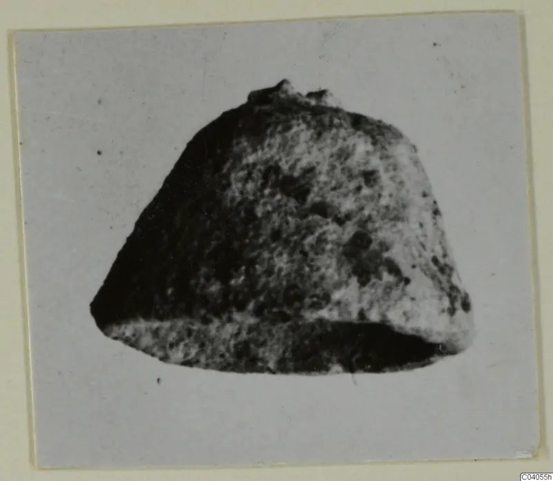 Heavily corroded bronze object, recorded as horse-trappings from Idalion, photographed on a card mount.
