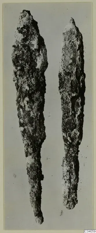 Two corroded iron weapons, long pointed blades shown side by side