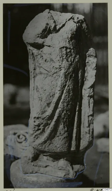 Weathered limestone sculpture of a draped standing figure from Mersinaki, head broken away