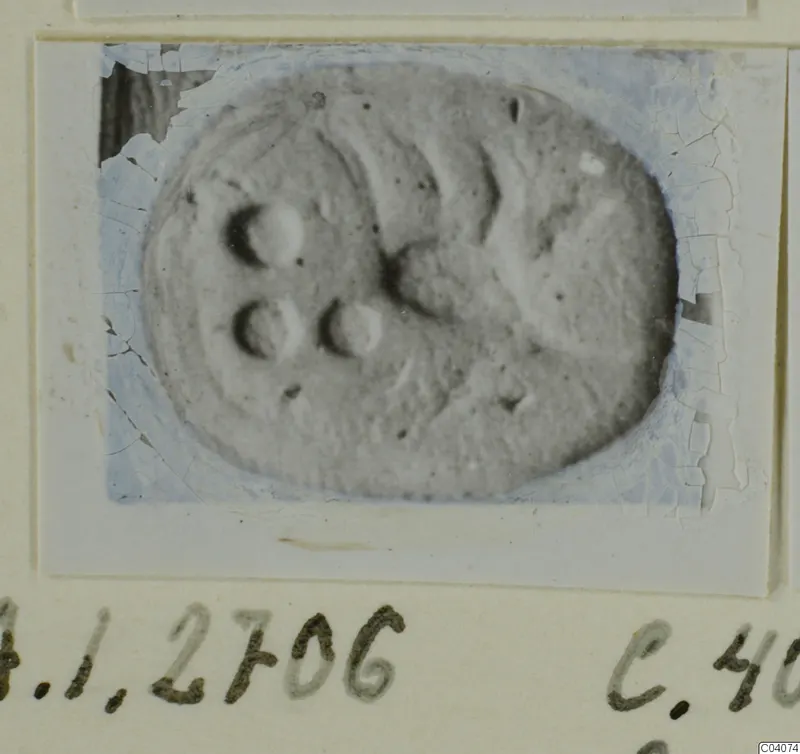 Oval glyptic object with round hollows and curved ridges on its surface