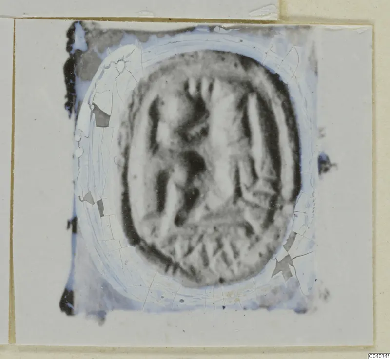 Oval seal or gem with carved figures, cracked and damaged, mounted on a card