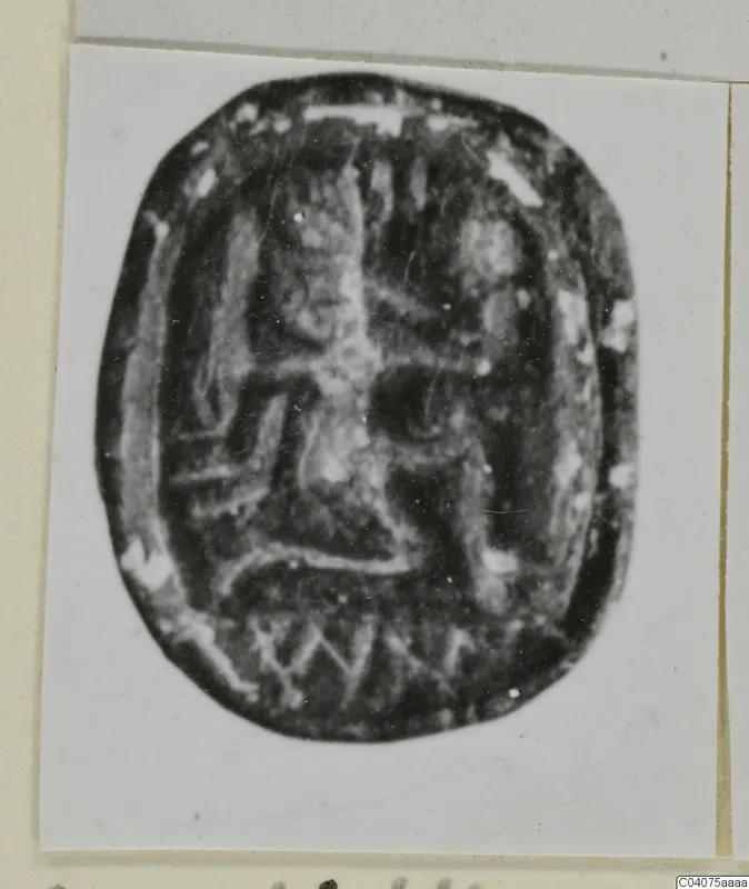Oval stone seal, scarab-shaped, with an incised design on its flat base, shown on a mounted card.