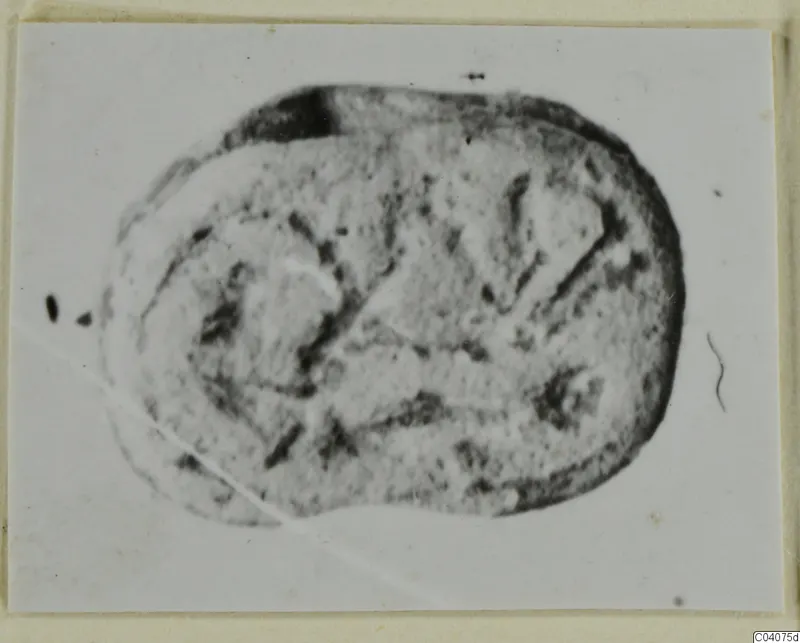 Oval seal or gem with incised marks and lines, shown face-on on a mounted card