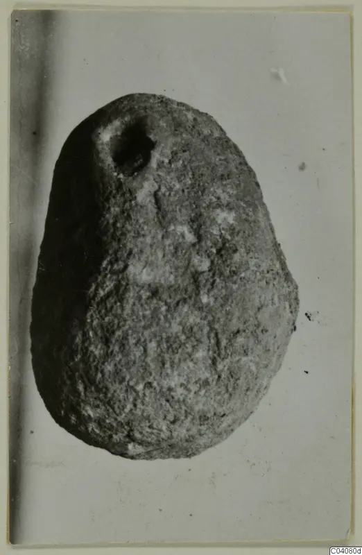 Egg-shaped object with a hole near its top, photographed against a pale background