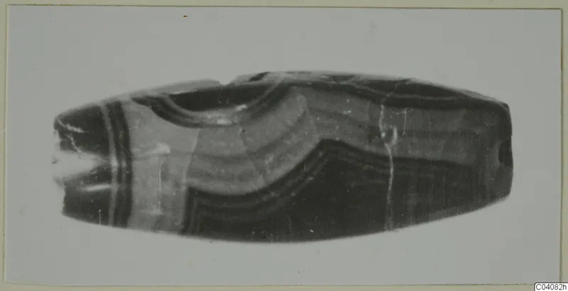 Elongated banded stone vase from Cyprus with wavy dark and pale stripes