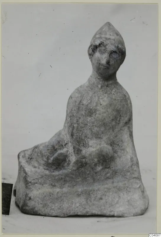 Seated terracotta figurine from Marion with a tall pointed head and a rounded body.