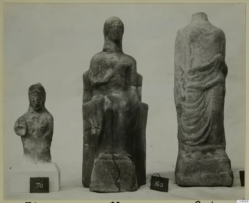 Three sculptures from Marion on a plain background, one seated, with dark number labels in front.