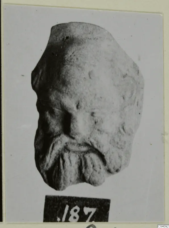 Terracotta head fragment of a bearded face, shown with a number label below