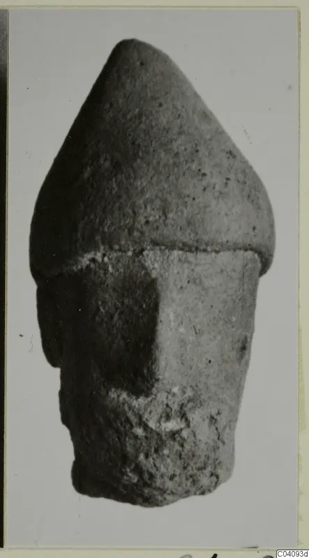 Small terracotta figurine with a tall conical top and cylindrical body, with a projecting form on one side