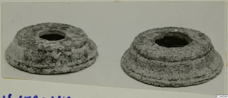 Two encrusted, stepped mounts with central holes, placed side by side on a card.
