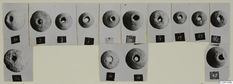 Mounted photographs of fourteen perforated round stone objects from Nitovikla T.I, with number labels
