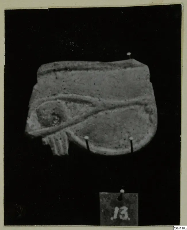 Relief fragment of a pale object pinned to a black background, with a small number label below it.