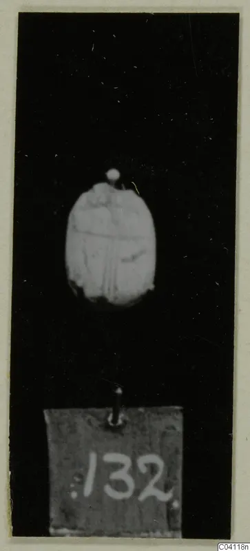 Engraved seal or scarab, oval, on a pin against a black background, with number label 132.