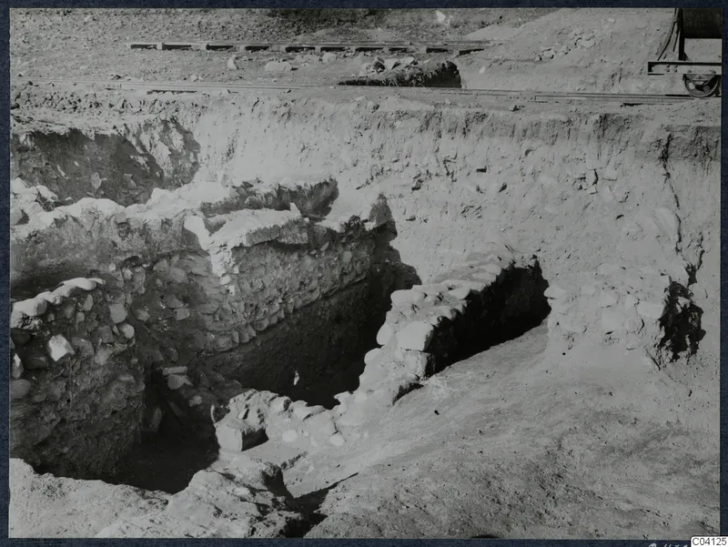 Excavation trench at Cholades, Soli, with stone walls and a narrow rail track running along the top of the cutting