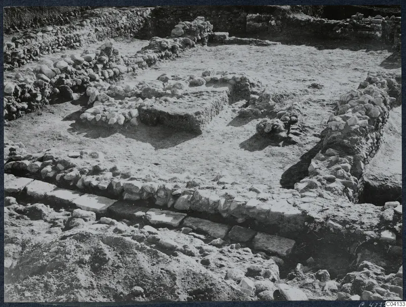 Excavation at Soli showing low stone walls and a stone-built platform in a cleared area