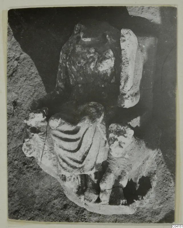 Fragmentary stone sculpture of a draped figure from Soli, photographed in a dark recess.