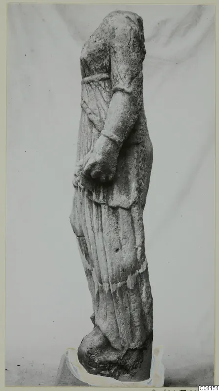 Stone statue of a draped standing figure from Soli, head and part of the arms missing.