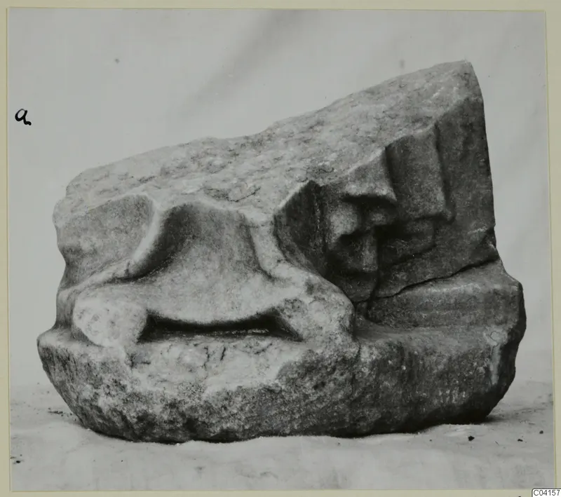 Marble sculpture fragment with a rounded raised form in the centre and a carved stepped profile on the right