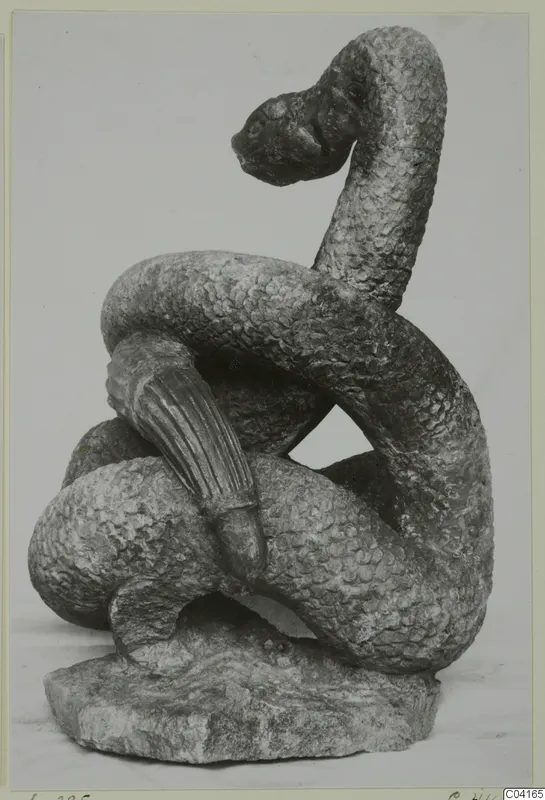 Stone sculpture of a coiled, scaled serpent-like figure with its head raised, from Soli