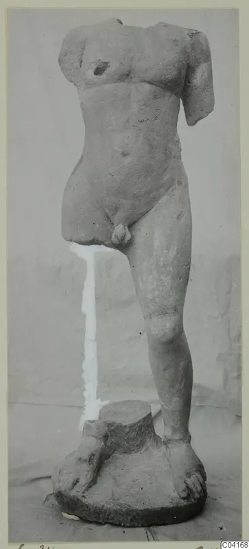 Stone statue of a nude male figure, headless and armless, standing on a circular base, from Soli