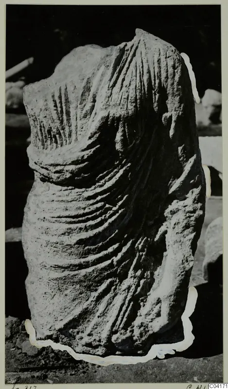 Carved stone sculpture fragment from Soli, showing a draped torso with deep folds