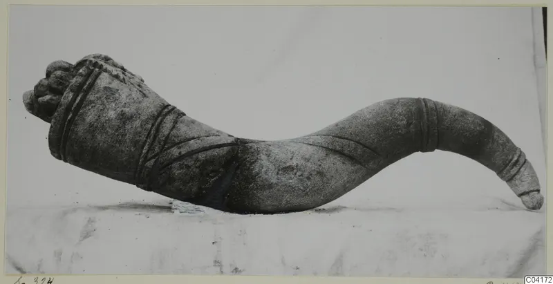 Carved stone sculpture fragment from Soli, curved and banded, photographed in profile on a pale cloth.