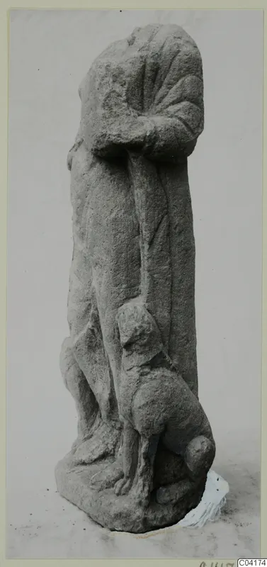 Stone sculpture of a standing figure in a long garment, with a small carved animal at its feet, from Soli