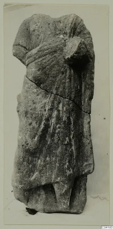 Headless stone statue of a standing draped figure from Soli, shown upright against a plain background