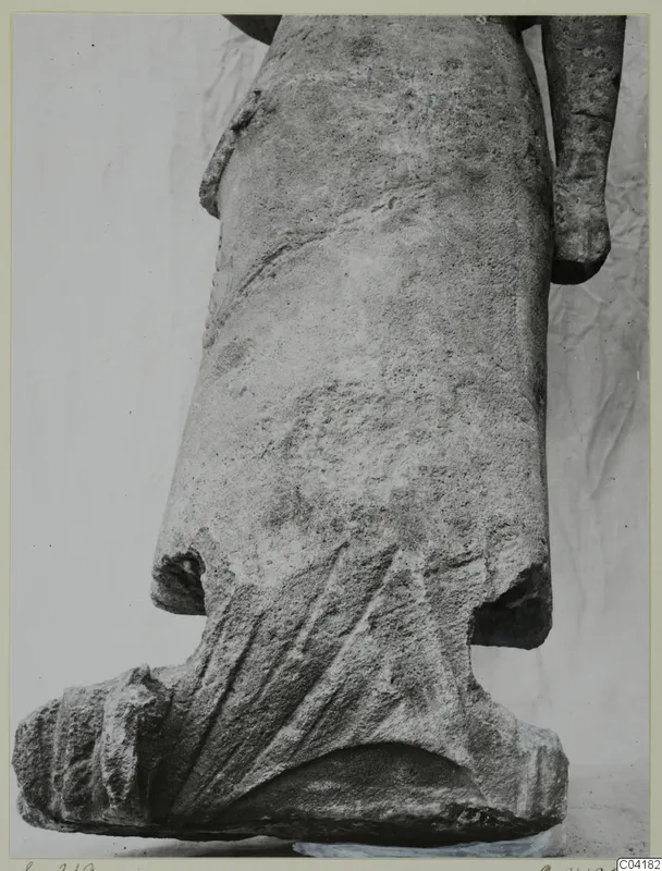 Stone statue fragment from Soli showing a draped lower body, fanned folds and a squared base