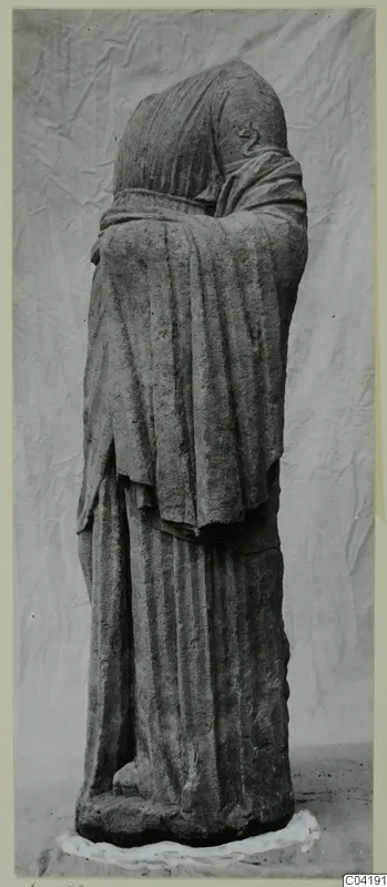 Standing stone statue of a draped figure from Soli, with head and shoulders wrapped in a heavy mantle.