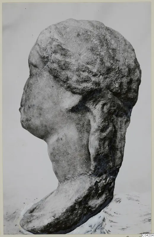 Profile of a carved marble head facing left, with wavy hair drawn back and a thick neck on a rounded base.