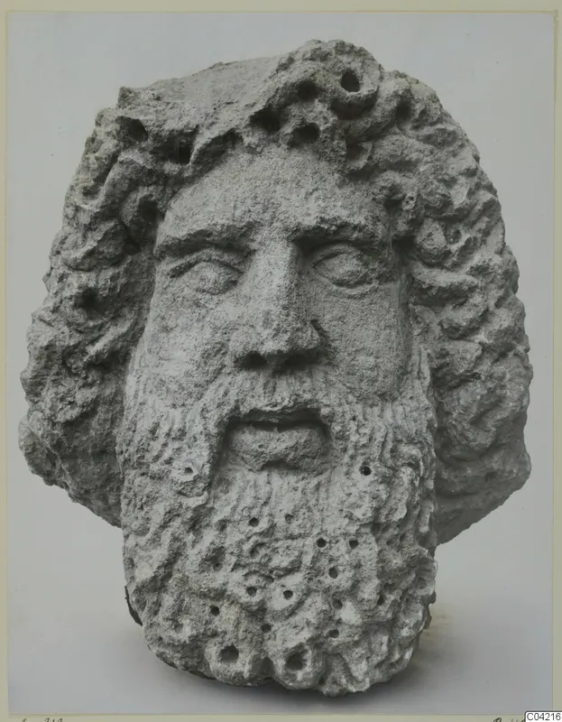 Stone head of a bearded figure with curling hair and a pitted surface, from Soli